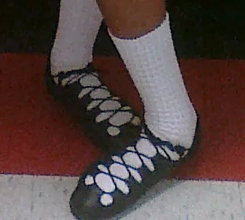 Black Irish dance ghillies worn with white poodle socks.