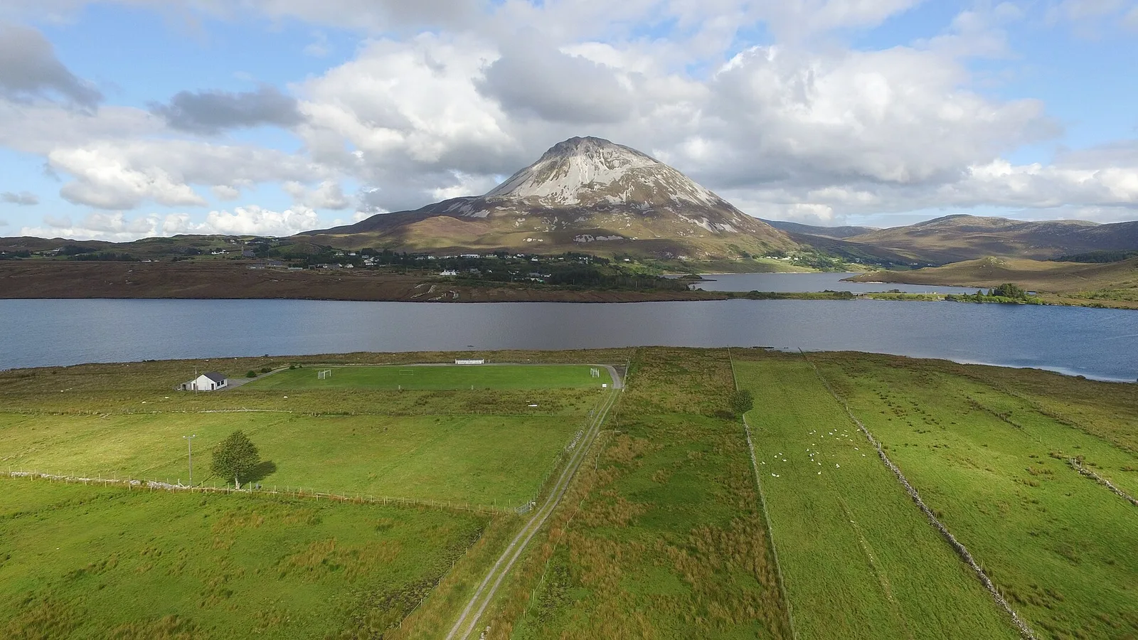 The pale rocky summit of Errigal rises above lakes and green fields near Dunlewey.