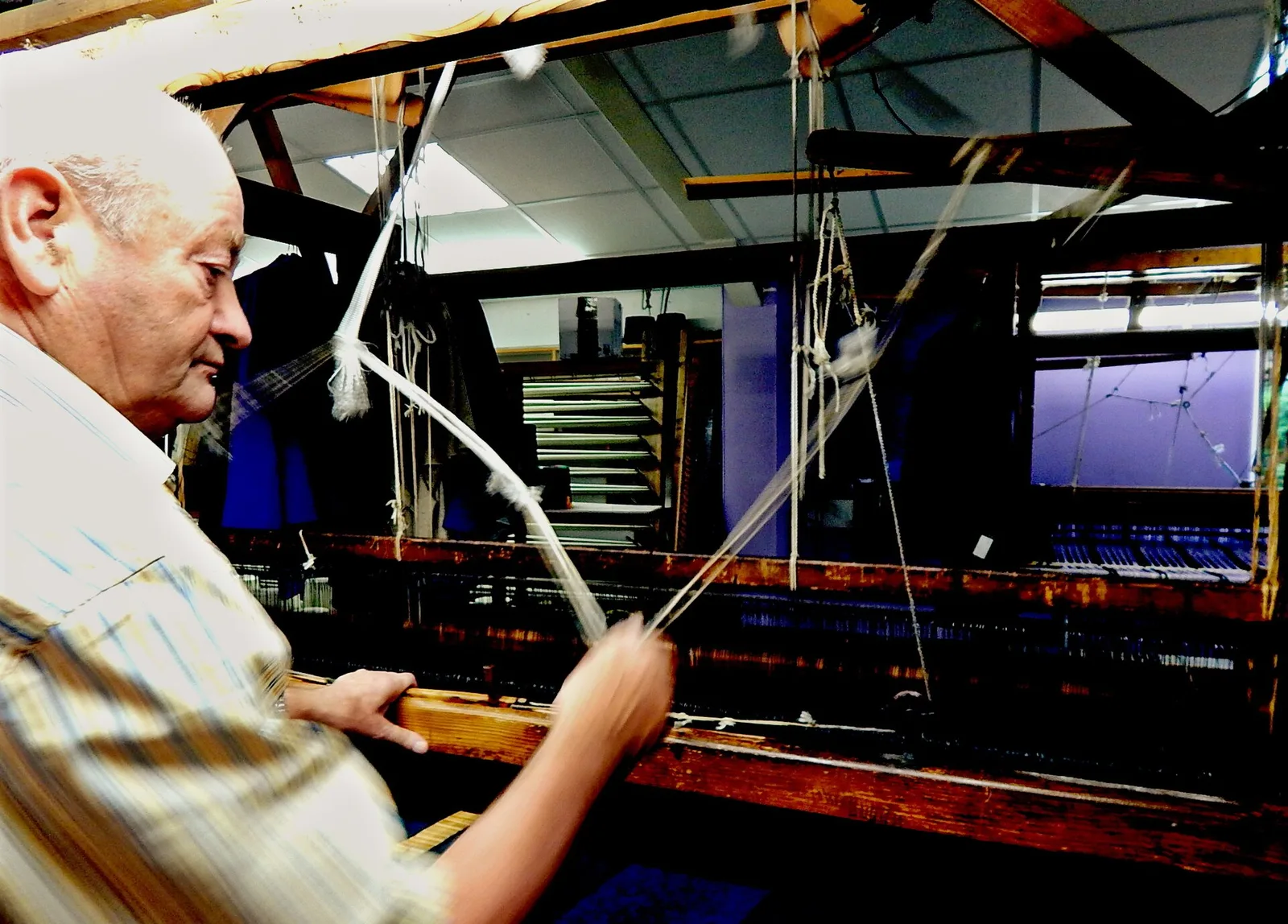 A weaver working at a loom inside Triona Design in Ardara.
