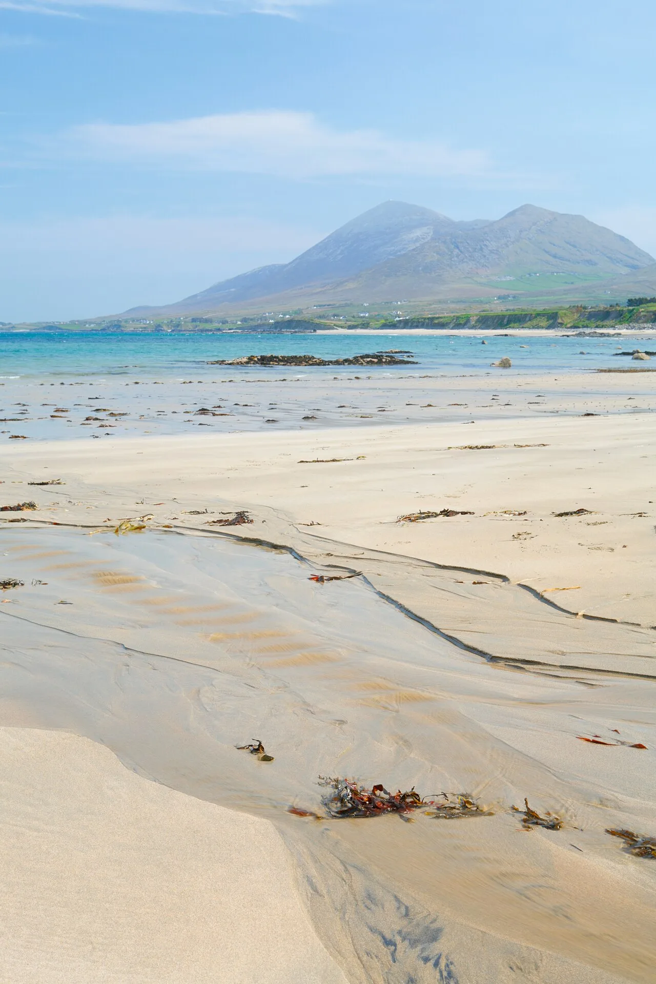 Croagh Patrick rising beyond the beach and blue water at Old Head.